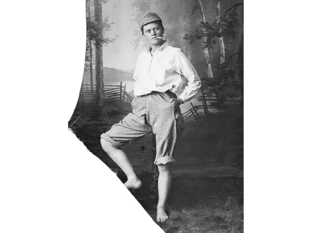 Marie Høeg i oppbrettede bukser, sixpence og sigarett i munnen.